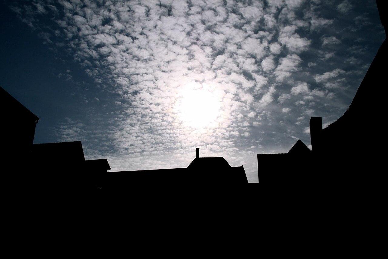 Silhouette of Odense rooftops against a dramatic cloudy sky near HCA Airport