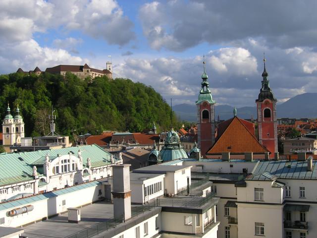 Ljubljana city center at dusk with illuminated Franciscan church and river bridge