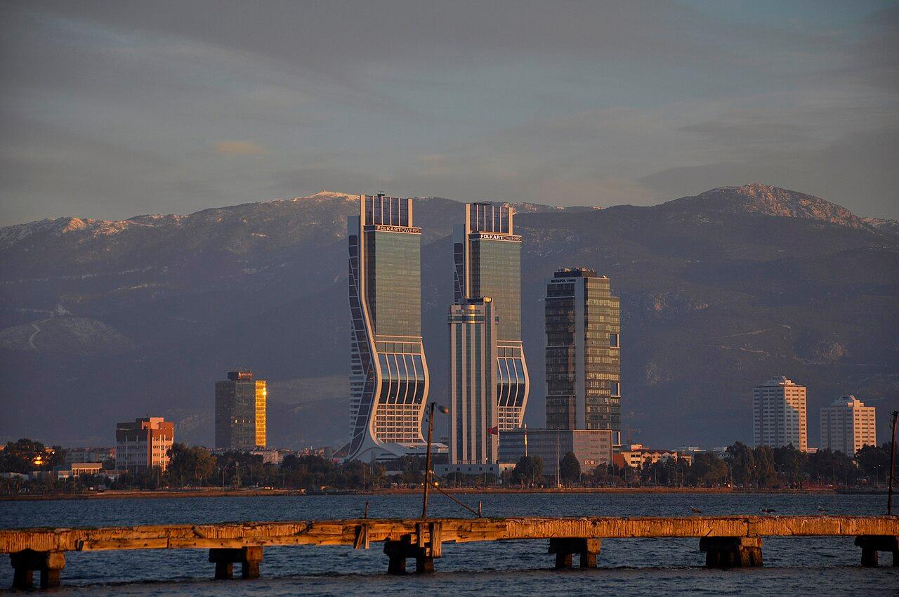 İzmir Adnan Menderes Airport apron with parked aircraft and mountain backdrop at dusk