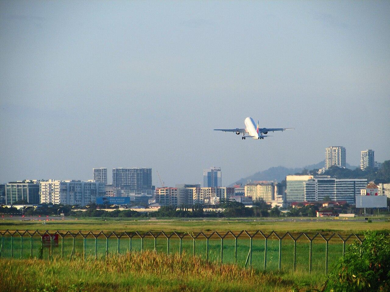 Malaysia Airlines aircraft on approach over Kota Kinabalu city skyline