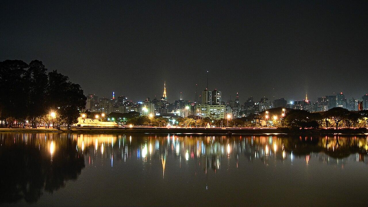 São Paulo city skyline at night reflected in Ibirapuera Park lake near Congonhas Airport